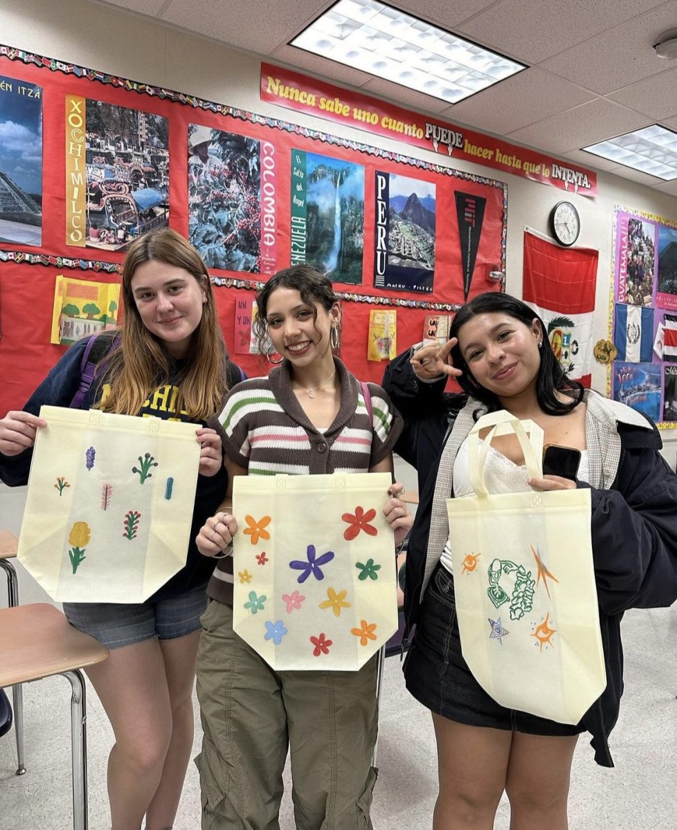 Students display their handiwork on tote bags after their last meeting. 