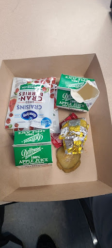 School lunch shown by portion size and nutritional variation with in brown container. 