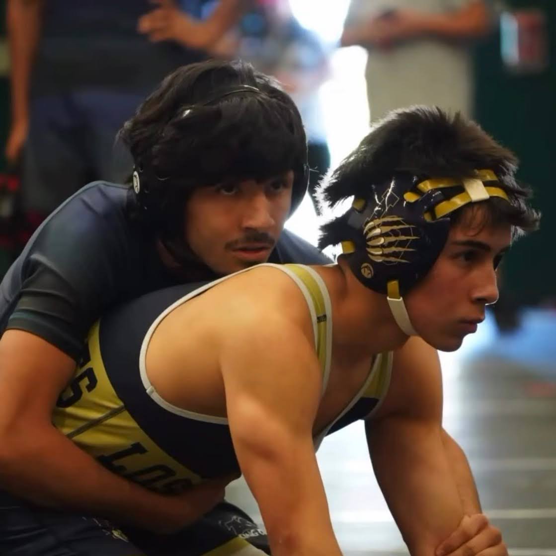 Two wrestlers are engaging in a one-on-one wrestling match, as the crowd anticipates who will come out victorious. (Instagram @lohs.wrestling)
